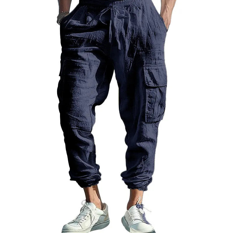 Men's loose-fit linen casual trousers with ankle ties and multiple pockets in a solid colour.