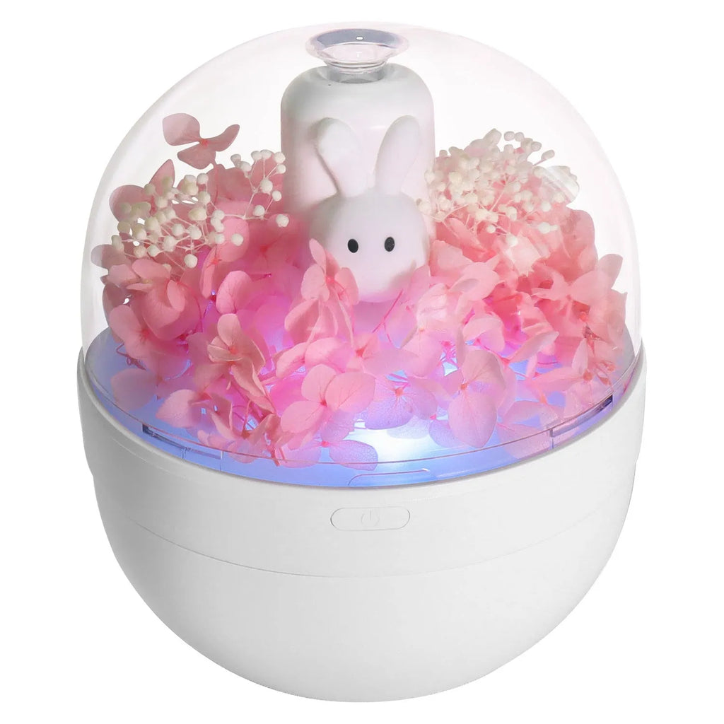 Pink rabbit-shaped aromatherapy humidifier with preserved flowers on top, USB powered for bedroom use.