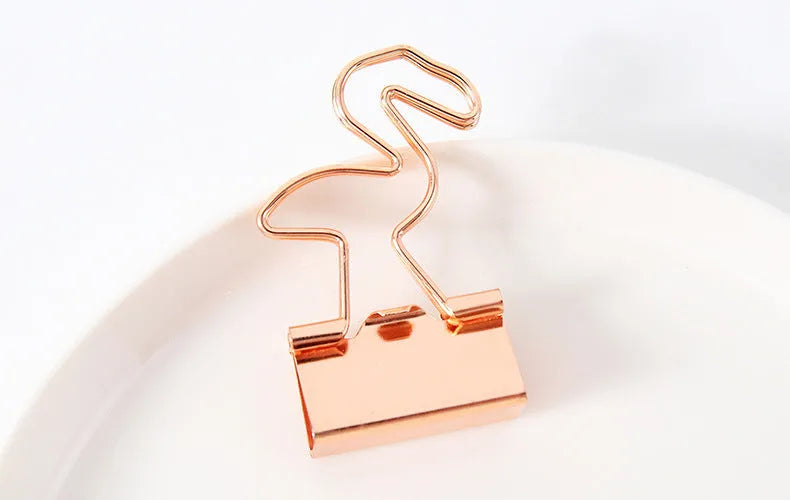 Small gold metal office clip with long tail, showing flamingo, love, cloud, cat, cactus, and bow shape options.