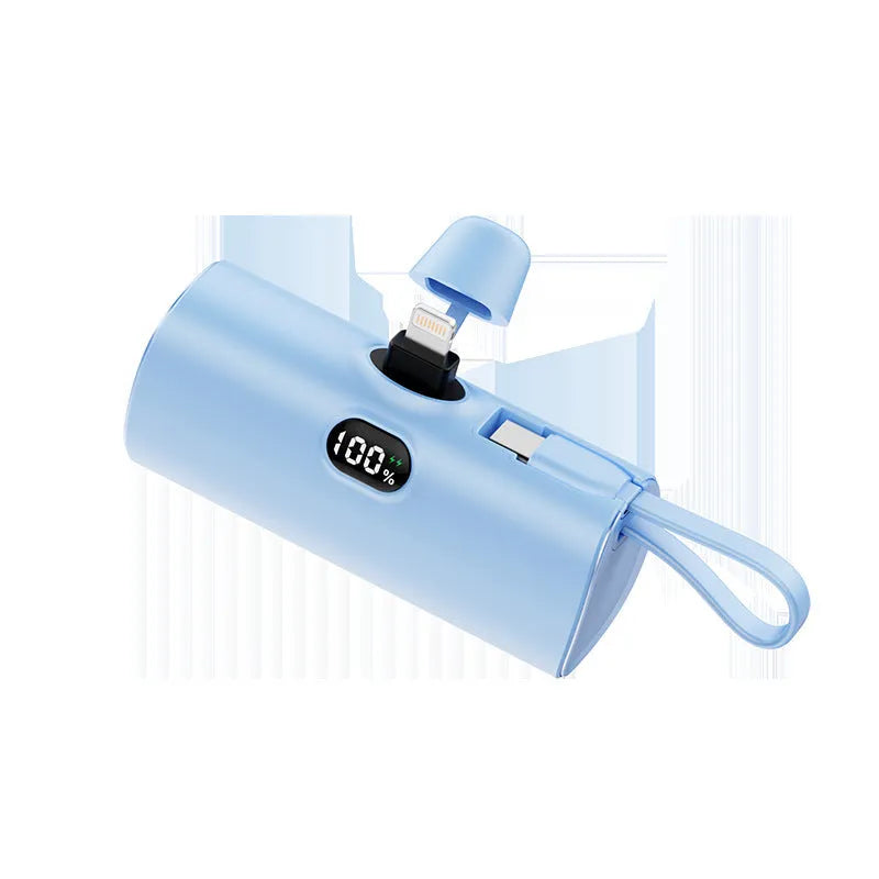 Compact capsule-shaped wireless power bank with a UK plug and digital display, shown in pink.