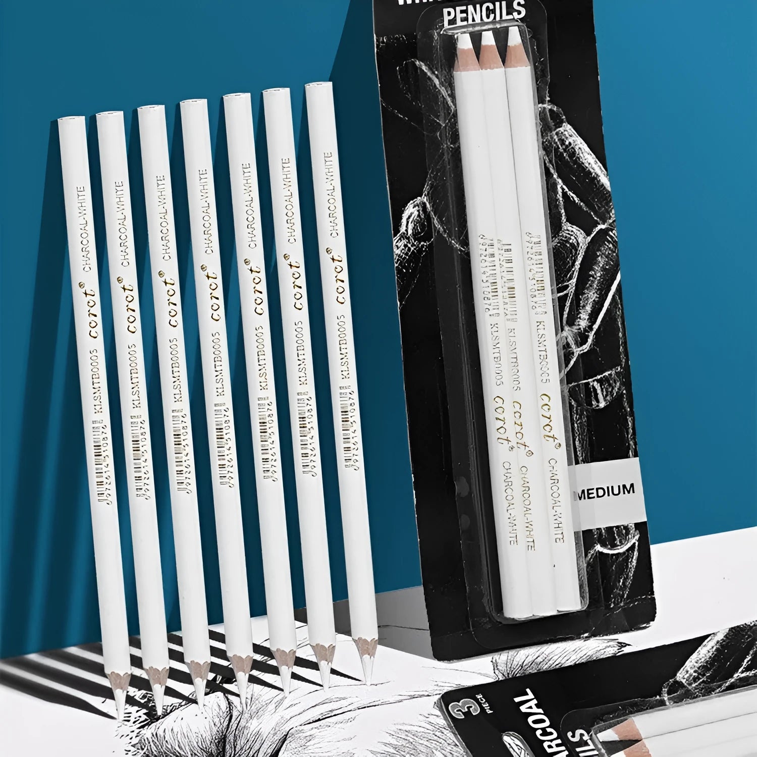 Three white charcoal sketching pencils with wooden shells on a dark surface.