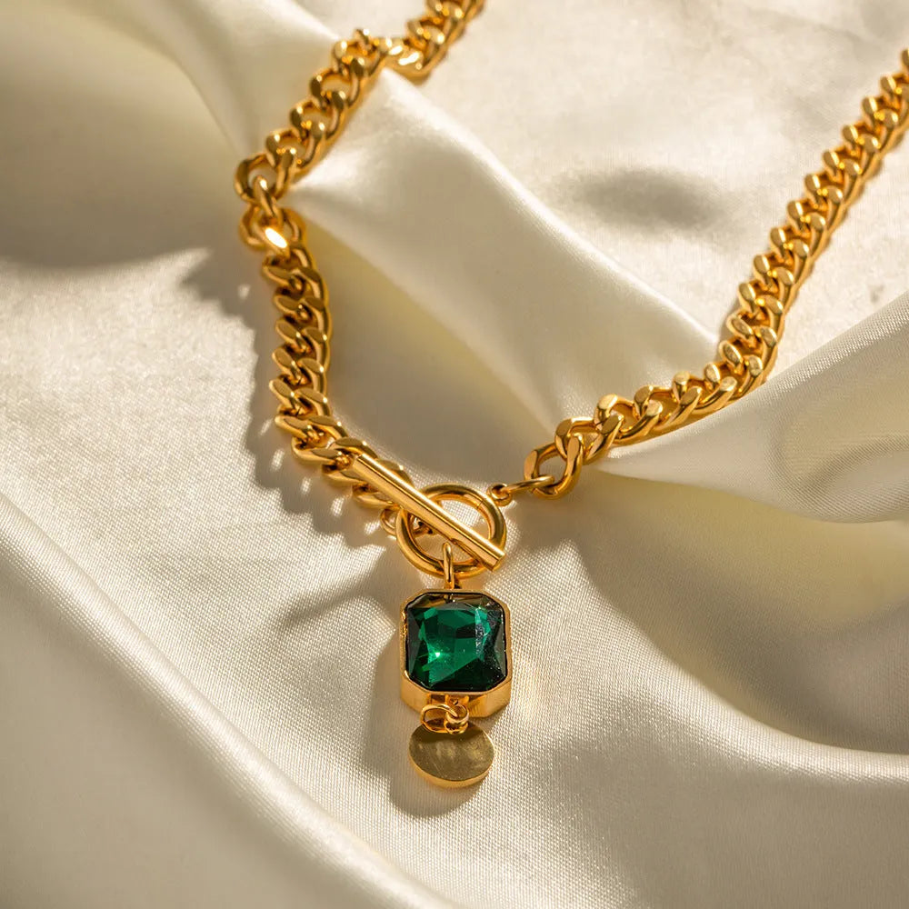 Gold French retro necklace with round geometric pendant featuring emerald zircon stone on Cuban link chain