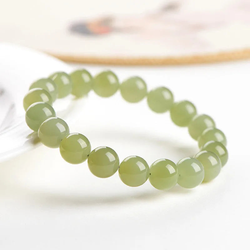 A polished Hetian jade ball bracelet showing beads in a clear ice-like colour on a wrist.