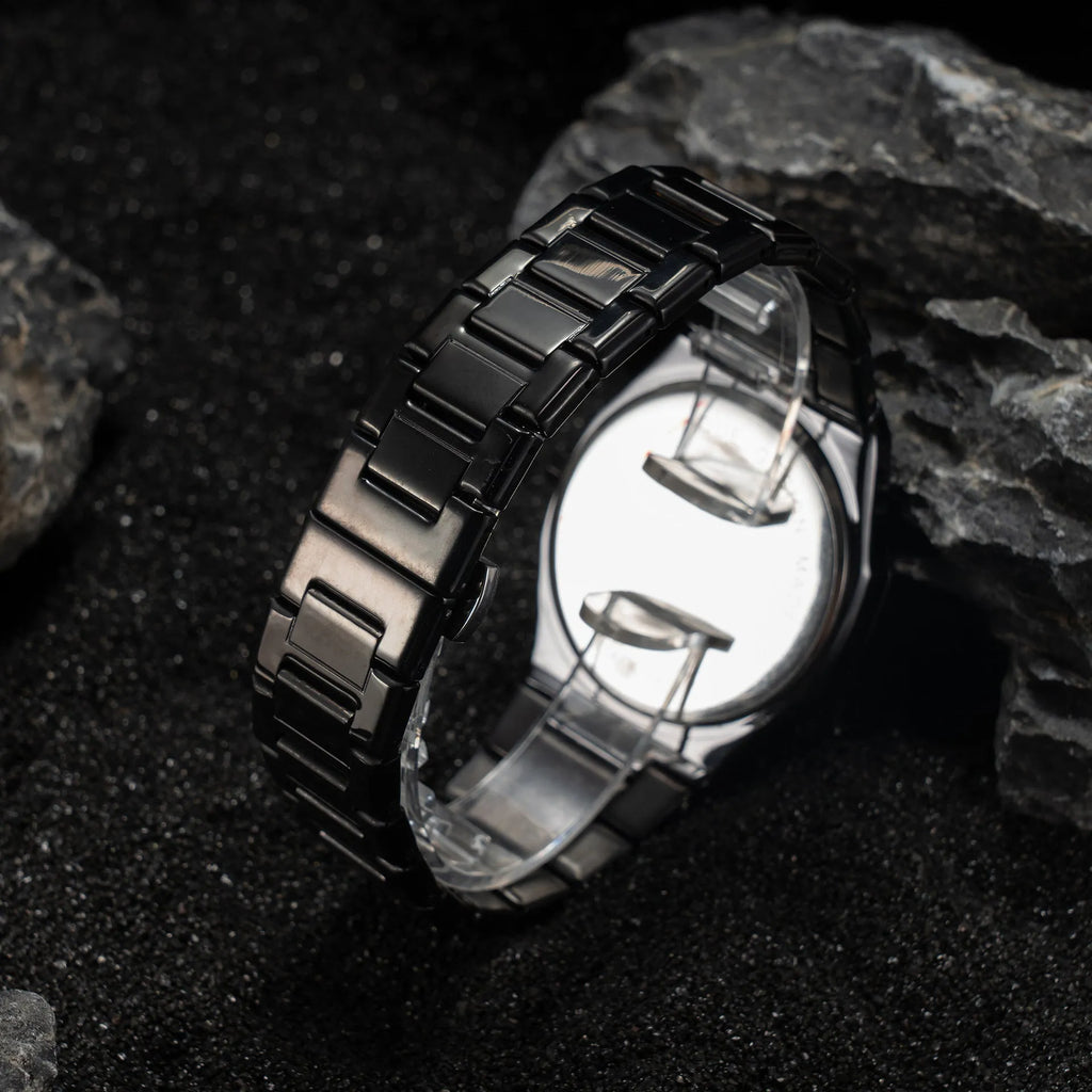 Men's silver and black business casual watch with steel bracelet and analogue dial on a wrist.