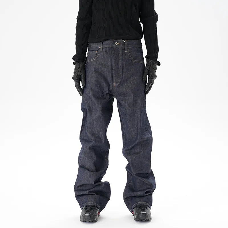 A pair of dark blue loose straight-cut jeans laid flat, showing the front design.