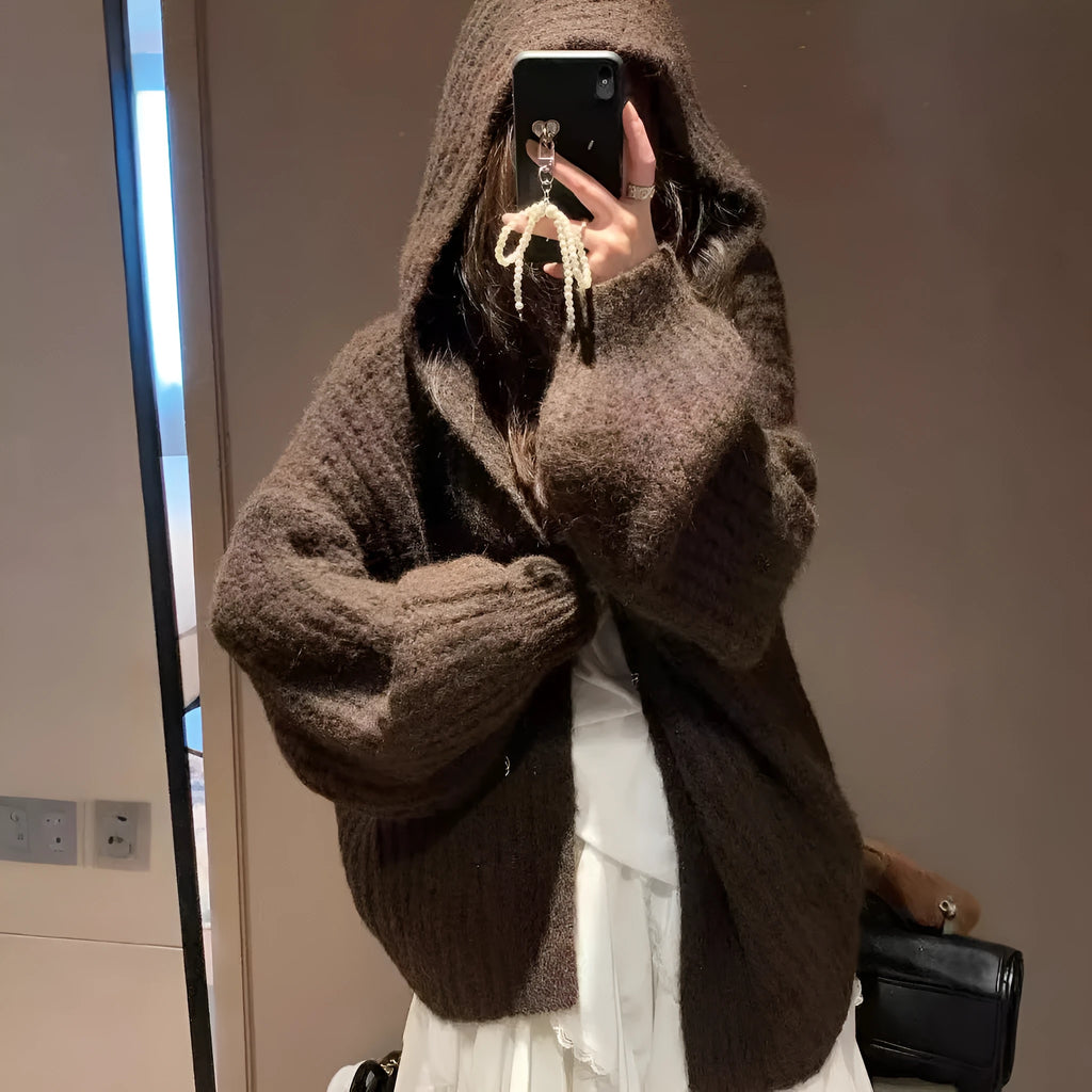 Women's loose grey hooded cardigan with a thick knit and oversized fit on a hanger.