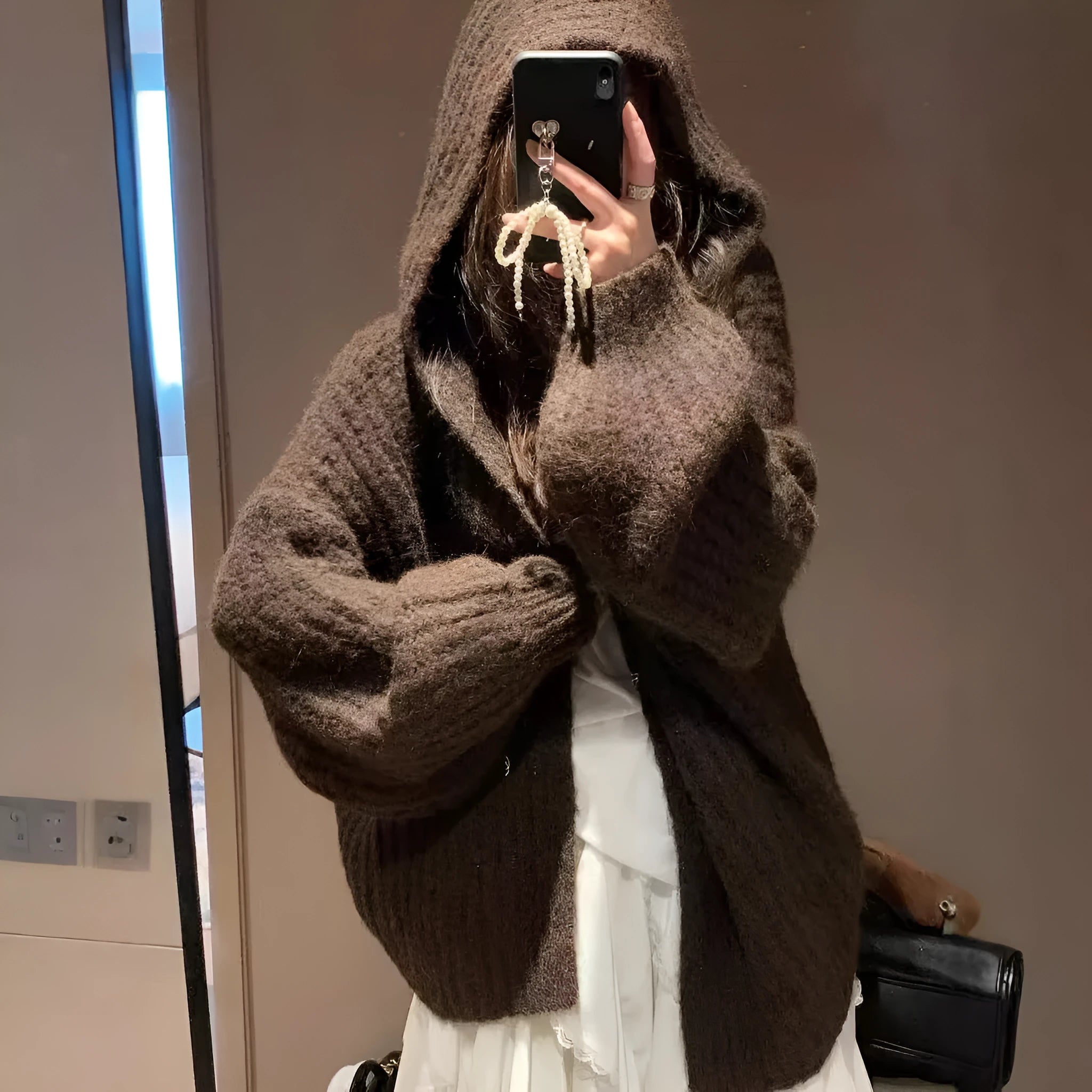 Women's loose grey hooded cardigan with a thick knit and oversized fit on a hanger.
