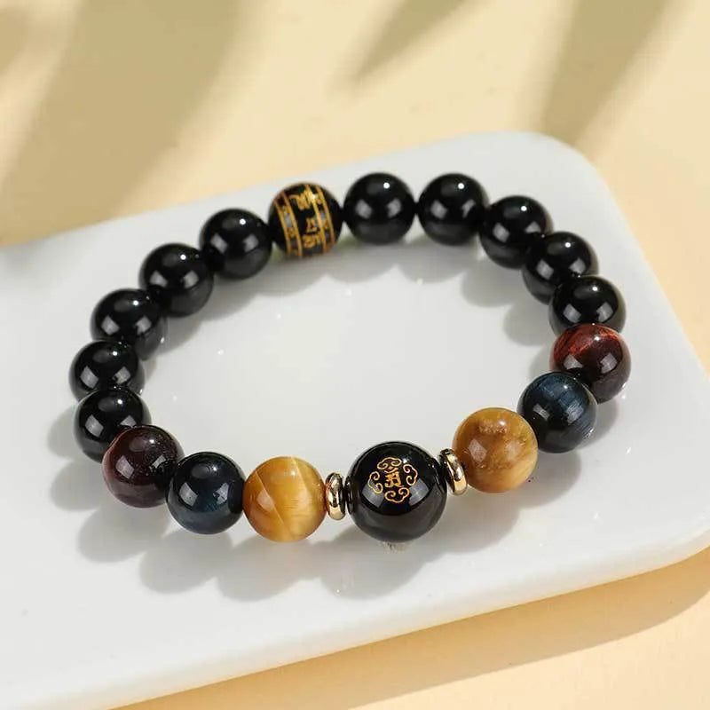 Handmade black agate beaded bracelet with gold, blue, and red tiger eye stones featuring Buddhist deity and zodiac animal motifs.