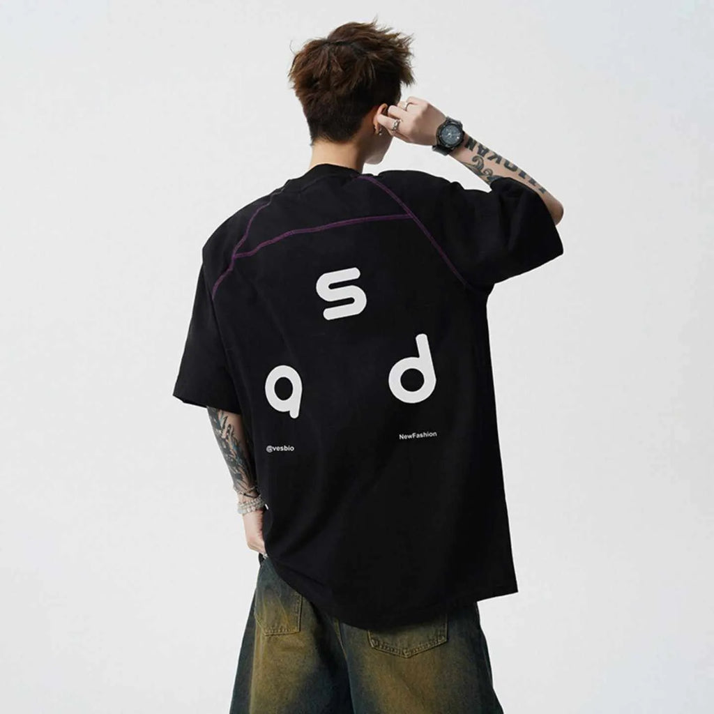 A loose-fit black cotton T-shirt with a white letter print on the front, showing a round neck and short sleeves.