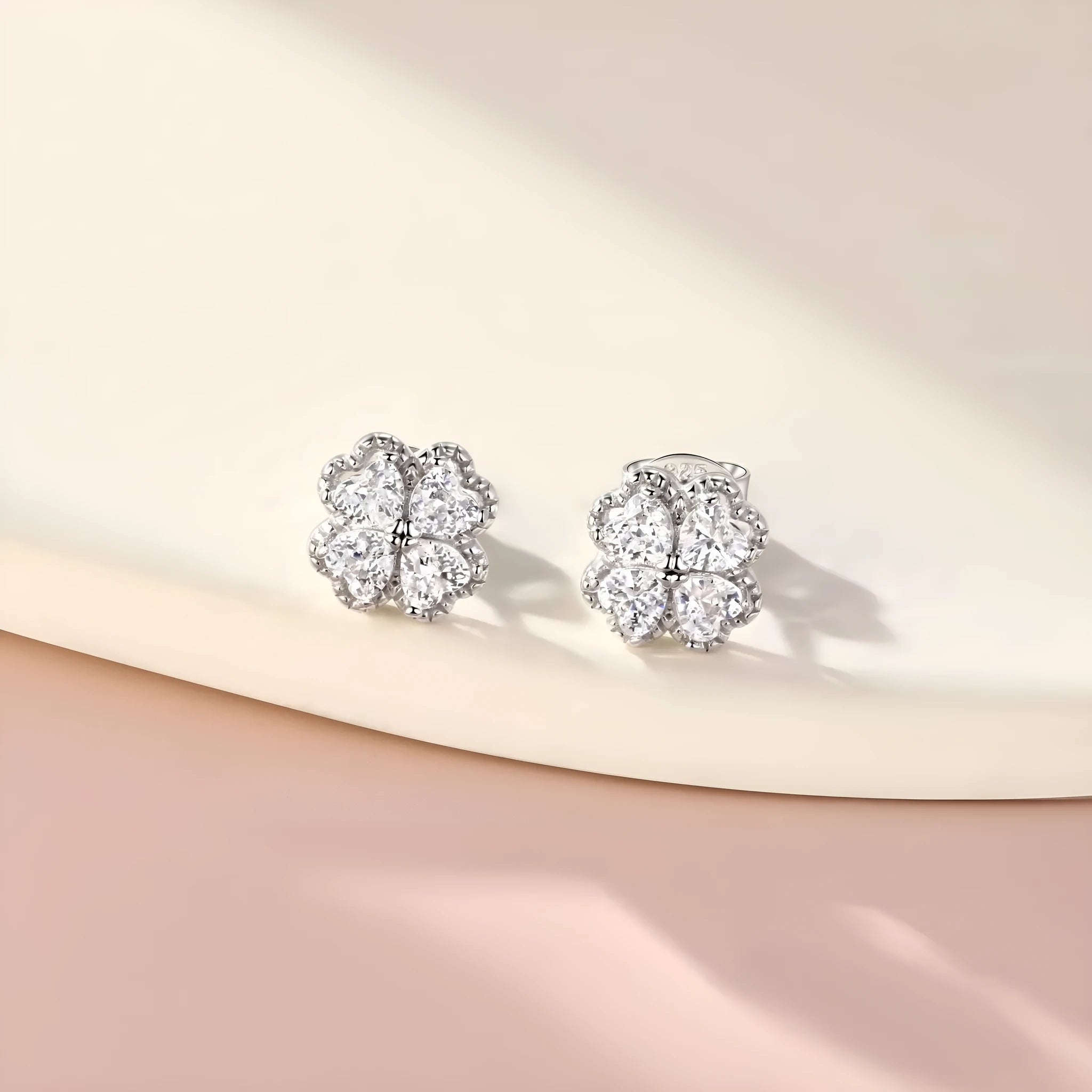 Pair of silver heart-shaped earrings with a four-leaf clover design and zircon stones in white gold colour.