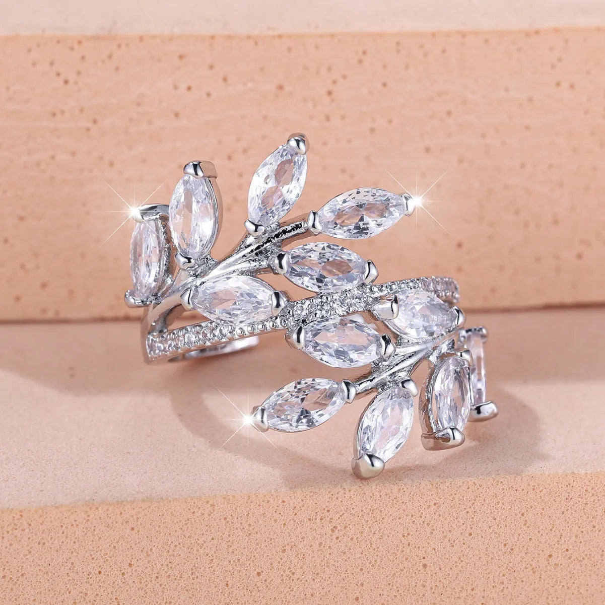 Close-up of an adjustable horse eye zircon leaf fashion ring in a rose gold finish with white stones.