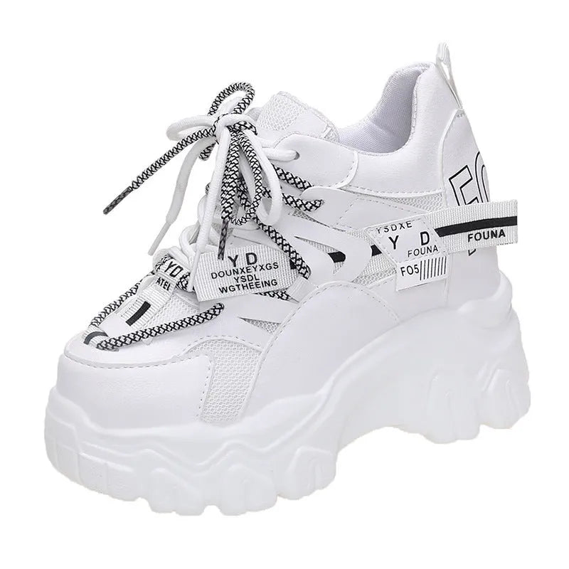 Women's white and black platform tennis shoes with mesh upper and cross-strap.