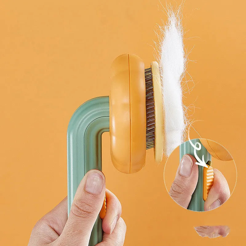 Hand-held pet grooming brush with curved stainless steel teeth in pumpkin colour option