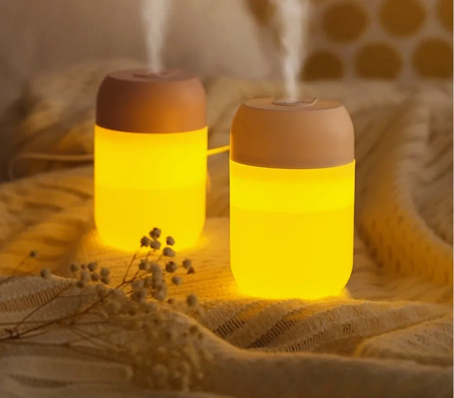 White cylindrical USB mini humidifier with mist output and charging cable