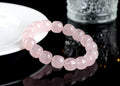 Close-up of a pink crystal bracelet with barrel-shaped beads on a wrist.