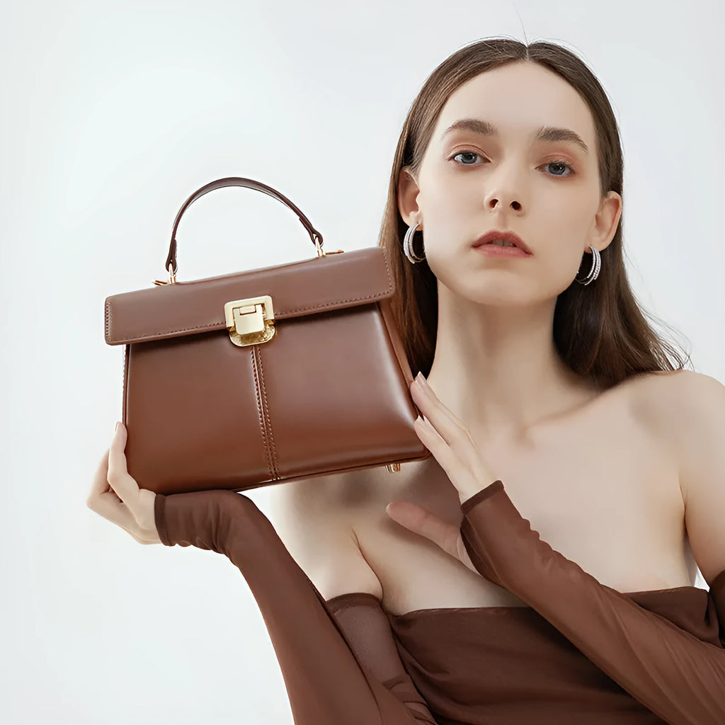 Black genuine leather women's shoulder bag with a vachette clasp, shown open to reveal a zippered hidden pocket.