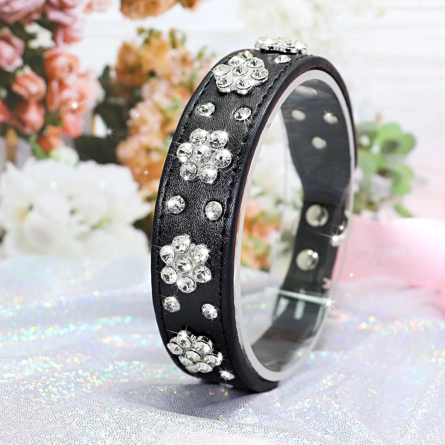 Black PU leather dog collar with sparkling rhinestone flower pattern and metal studs, showing adjustable eyelets and D-ring.