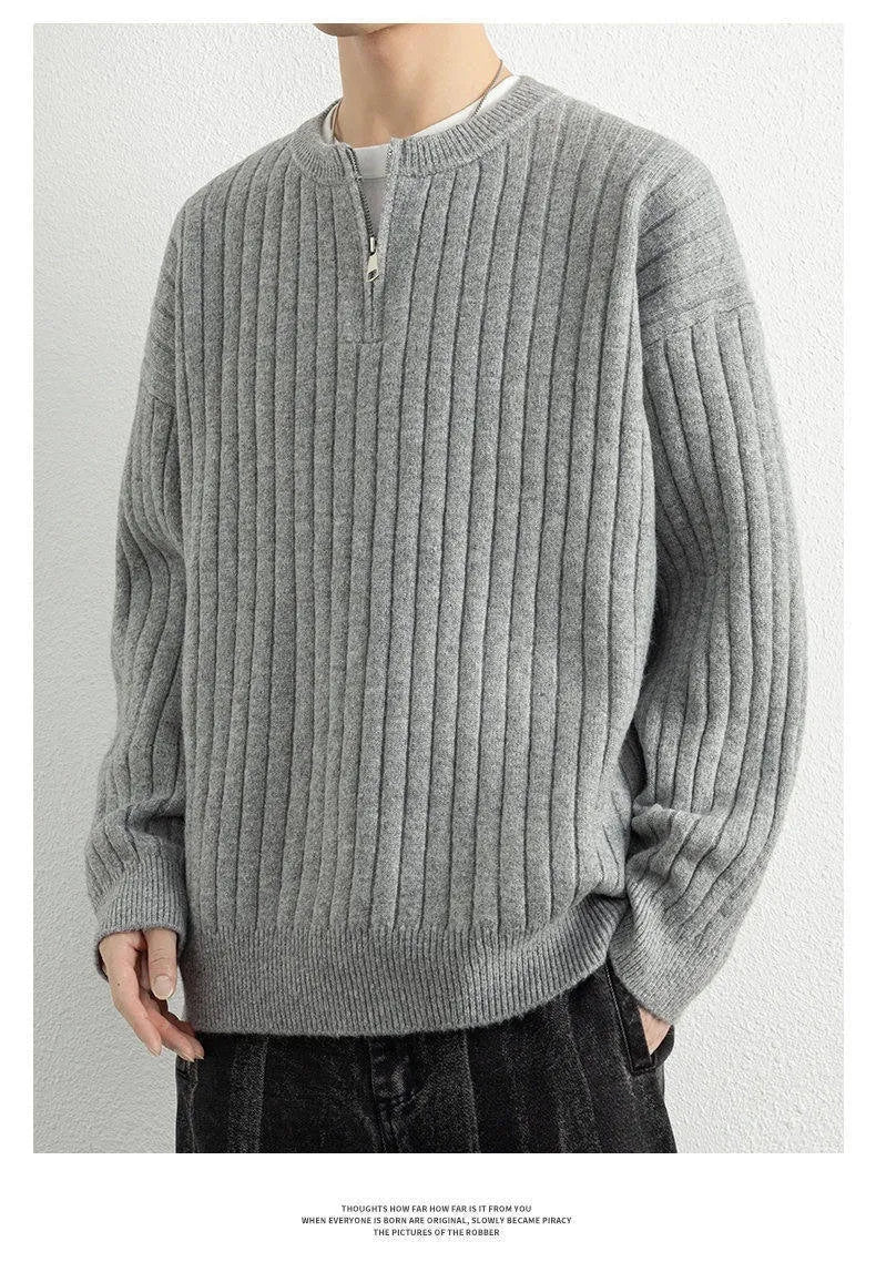 A grey men's loose fit half zip pullover sweater with a textured knit and long sleeves.