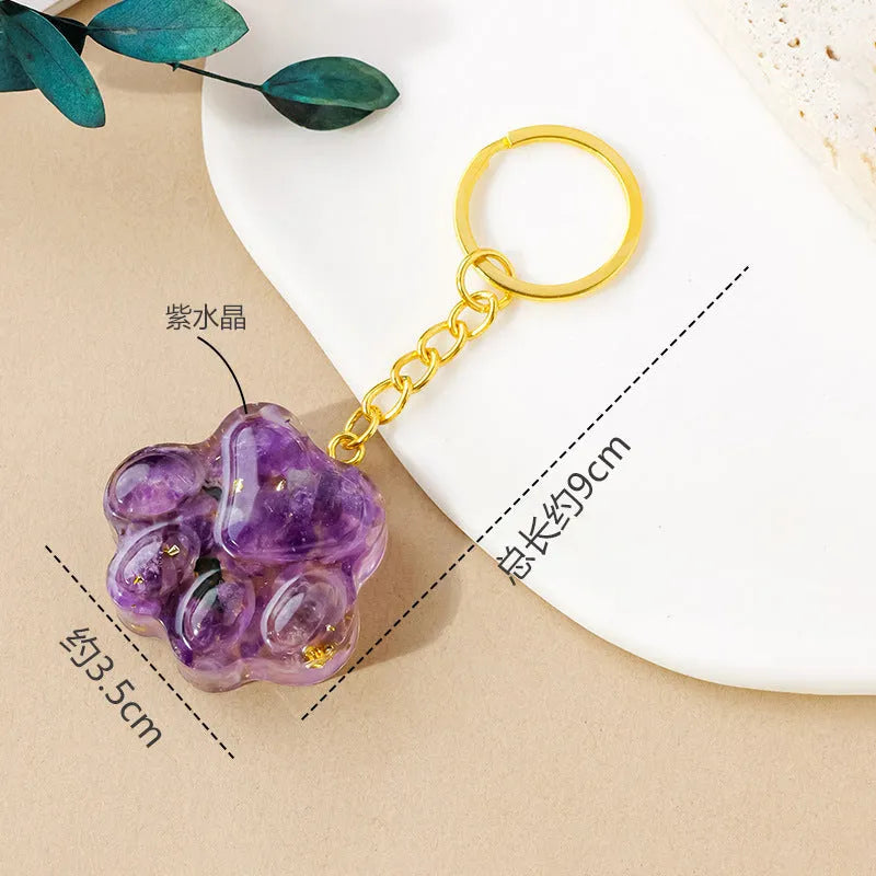 Small natural crystal cat's paw shaped keychain pendant on a keyring.