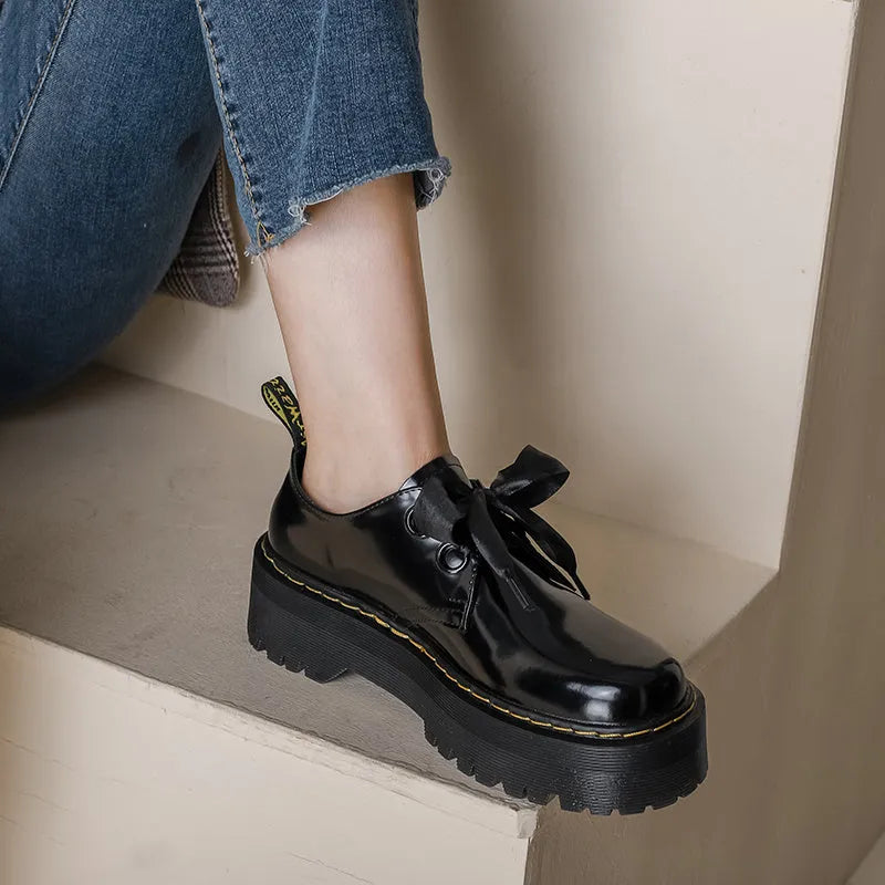 Women's black thick soled leather shoes with cross strap and ribbon lacing closure