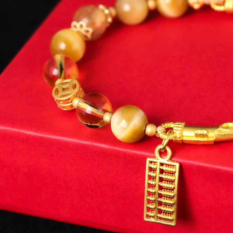 Handmade beaded bracelet featuring tigereye and citrine stones with yellow tower crystal and diamond-shaped copper parts