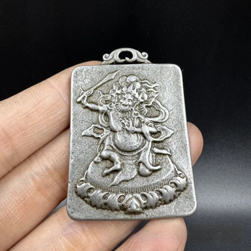 Close-up of an antique iron pendant with Chinese geometric patterns, design Aryaacalanatha Yamantaka.