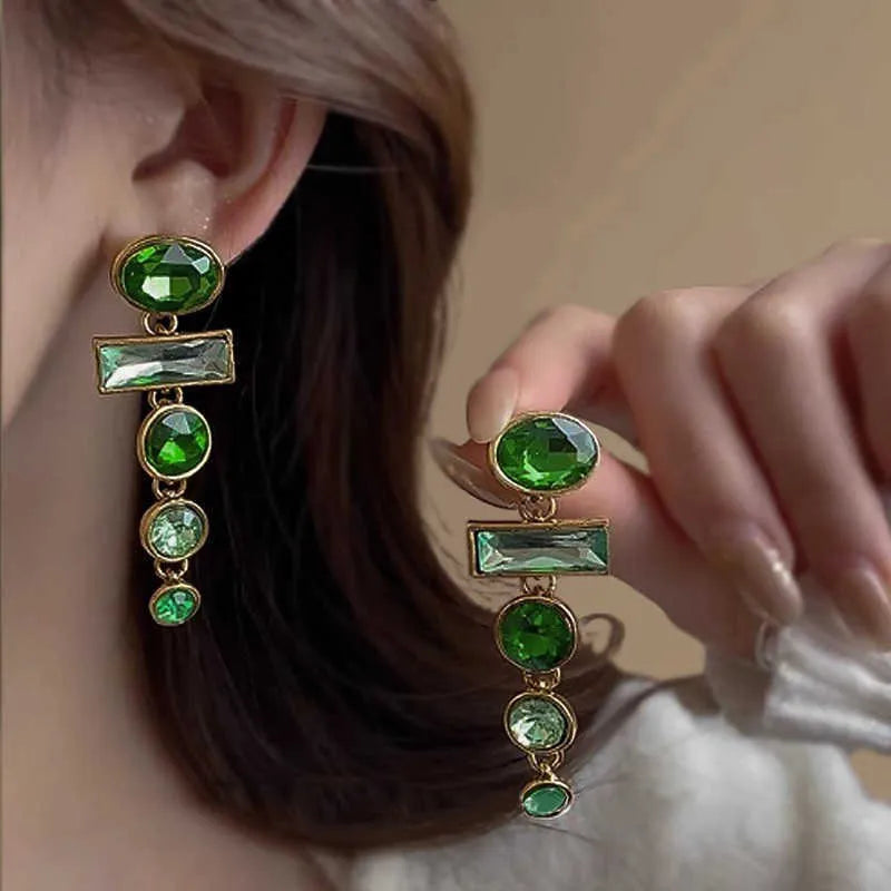 A pair of green gradient tassel earrings with a geometric shape and inlaid zircon detail.