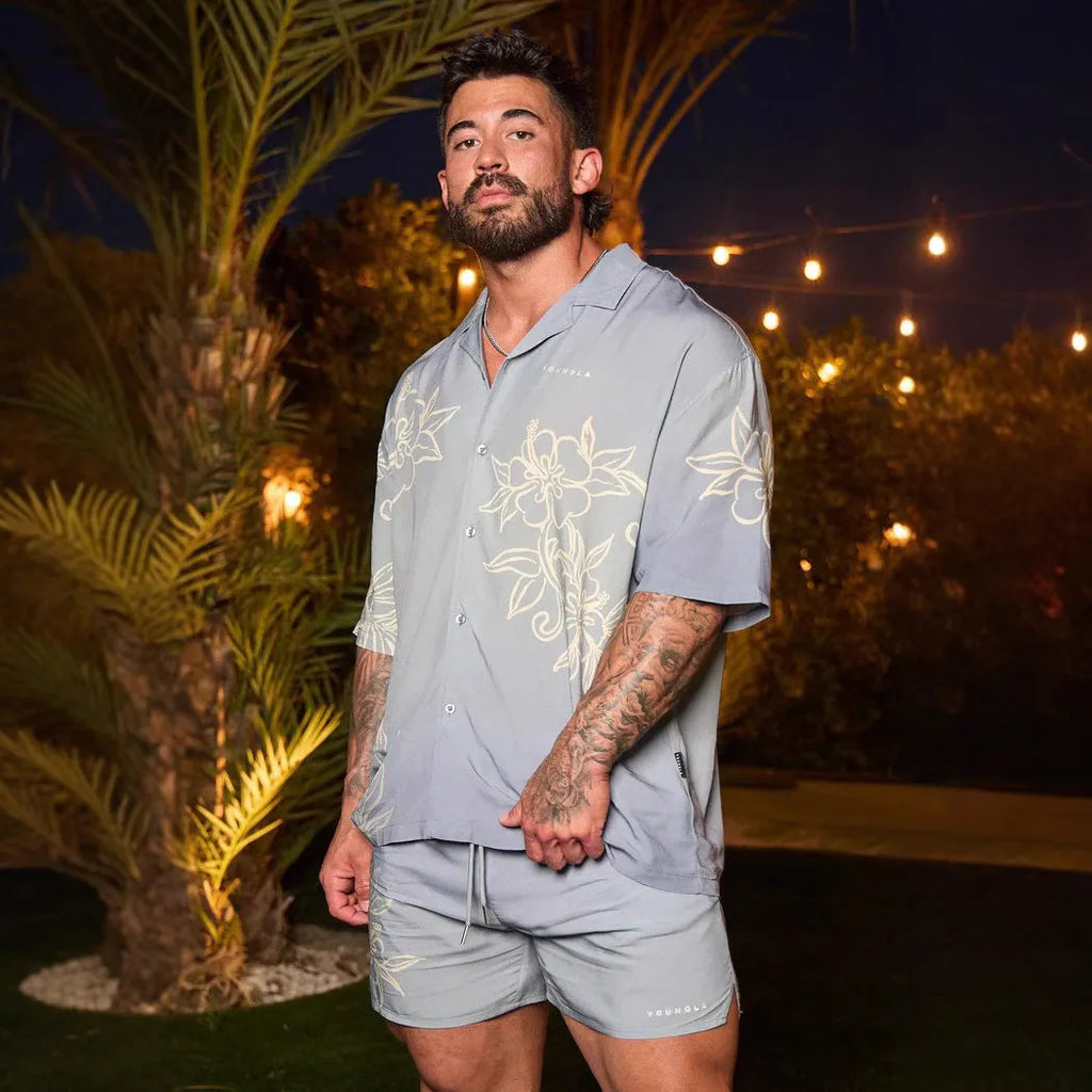 A loose-fitting short sleeve top with a floral print in a light colour, laid flat.