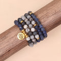 Close-up of a blue patterned network stone bead multi-layer alloy bracelet on a wrist.