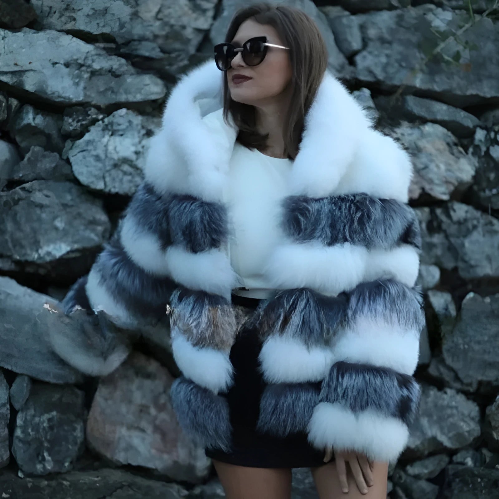 A woman wearing a loose-fit brown artificial fur hooded coat of medium length.