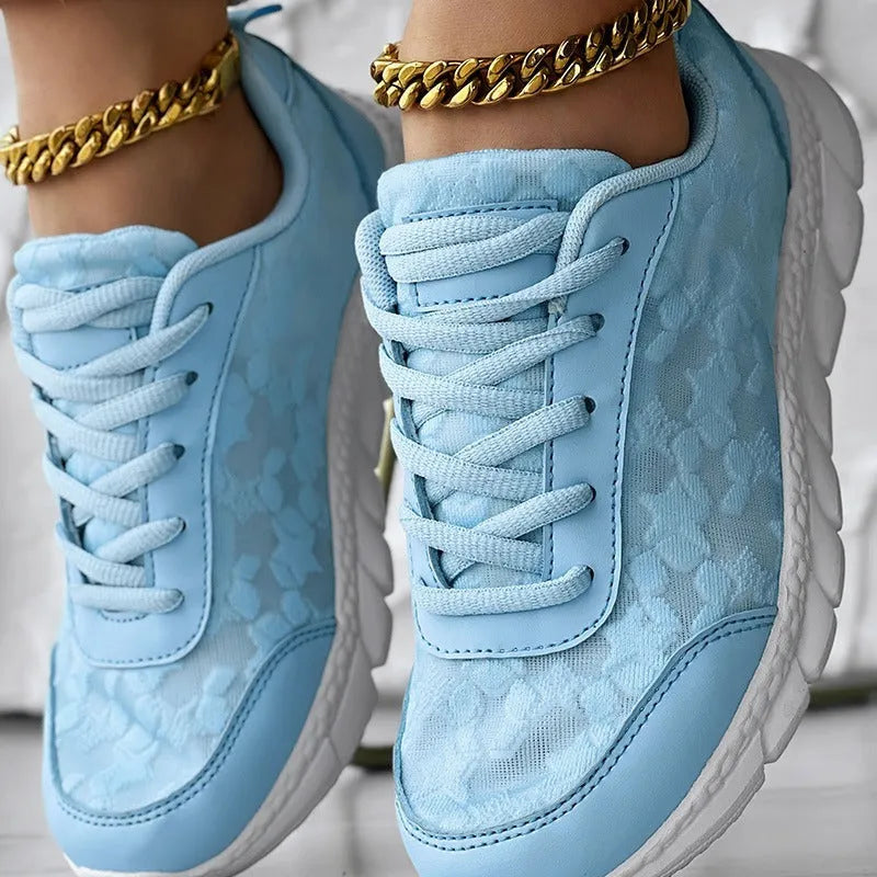 Women's white canvas casual running shoes with a soft sole and round toe on a plain background.