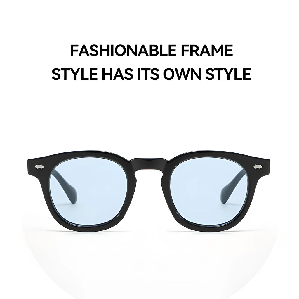 Round retro plastic sunglasses on a table, showing bright black frame with grey lens.