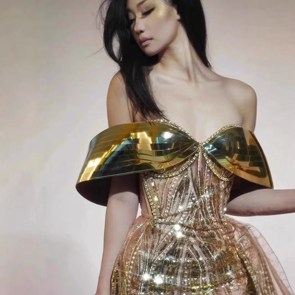 Gold strapless sequined formal dress with a side split on a long tulle skirt.