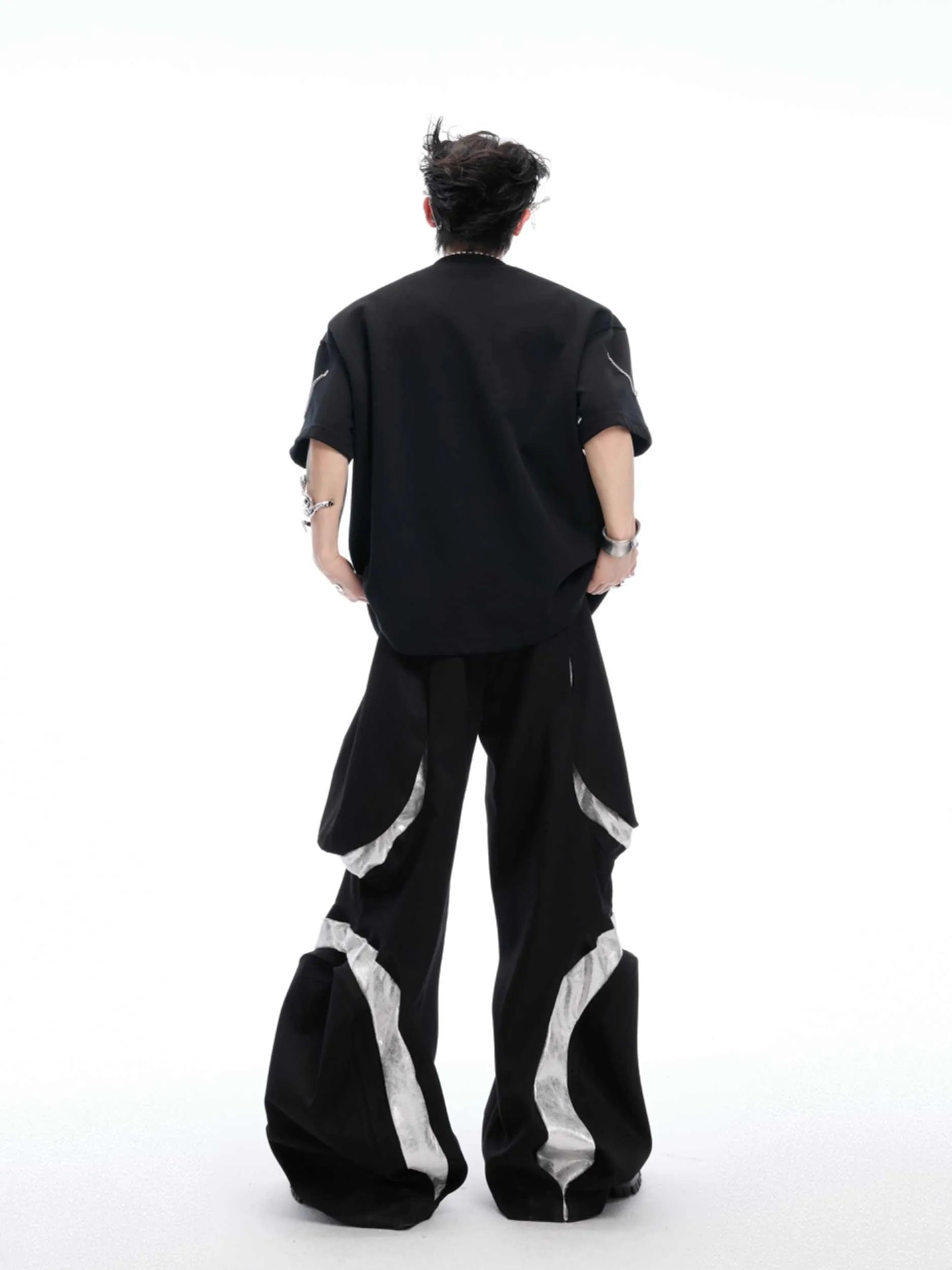Black T-shirt with padded shoulders and metal chain detail on short sleeves