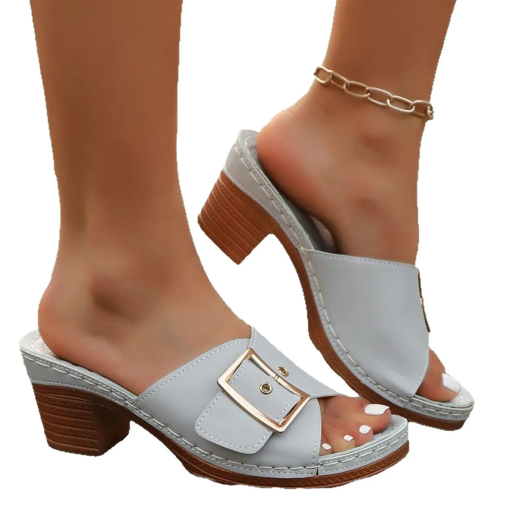 Women's black chunky heel slippers with a silver metal buckle and a round toe.