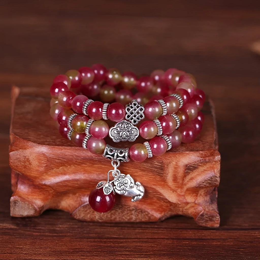 Handmade bracelet with geometric watermelon crystal beads and a Chinese knot closure.