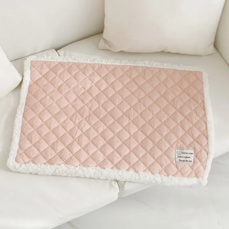 Quilted terry cloth cat blanket in blue, shown on a pet bed.