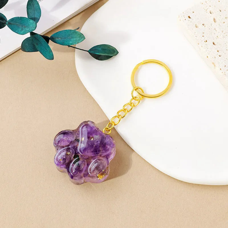 Small natural crystal cat's paw shaped keychain pendant on a keyring.