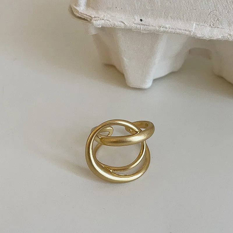 Women's geometric open ring with 3D interlaced pattern in matte metal with gold plating