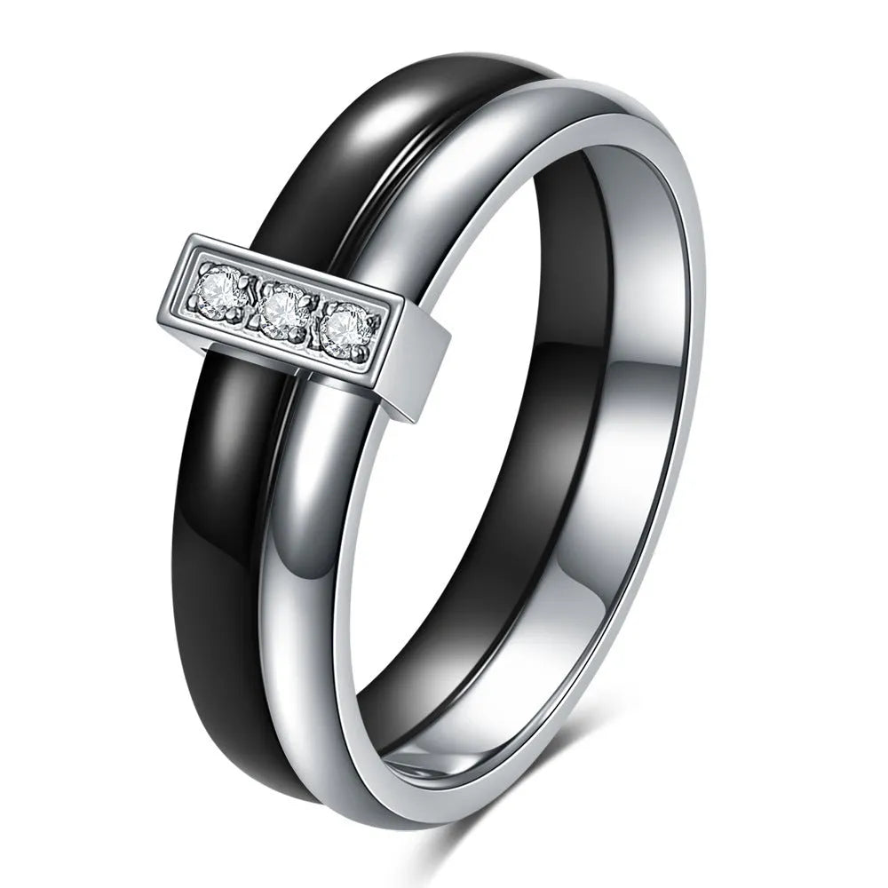 Glossy black ceramic women's ring with geometric shape and inlaid zirconium details on a finger.