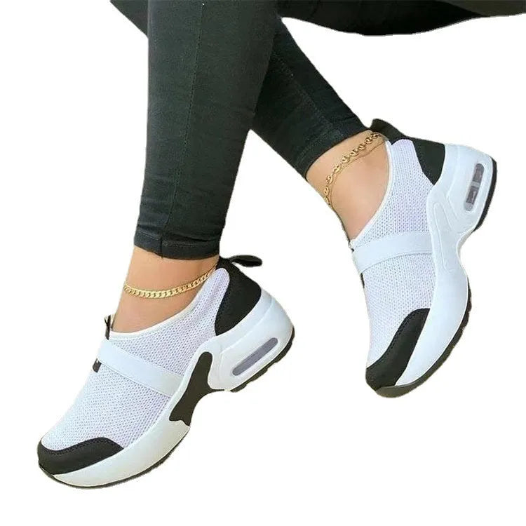 Women's white mesh flat sneakers with a round toe and non-slip rubber sole.
