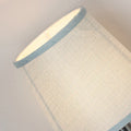 Modern minimalist fabric drum lampshade in a mini size on a table lamp base.