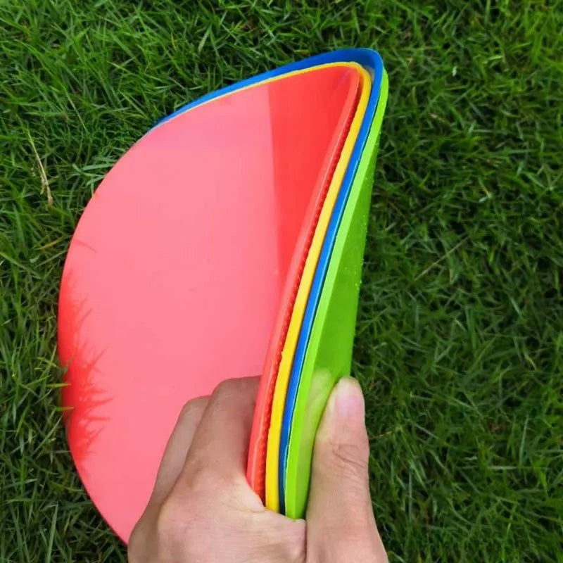 Yellow TPE football training landmark pad, 23cm diameter flat disc on grass.