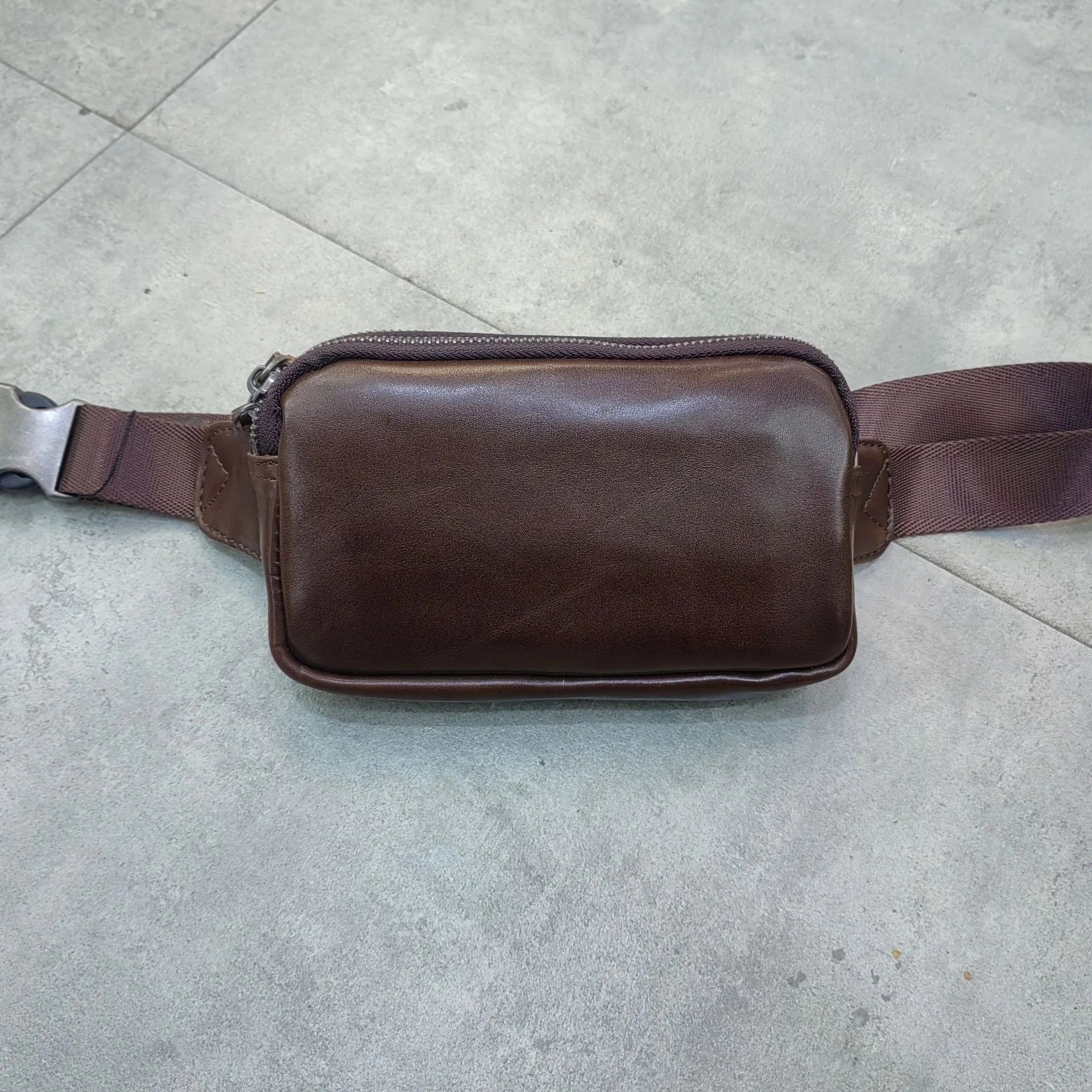 Men's small leather crossbody bag in black showing 17cm width dimensions