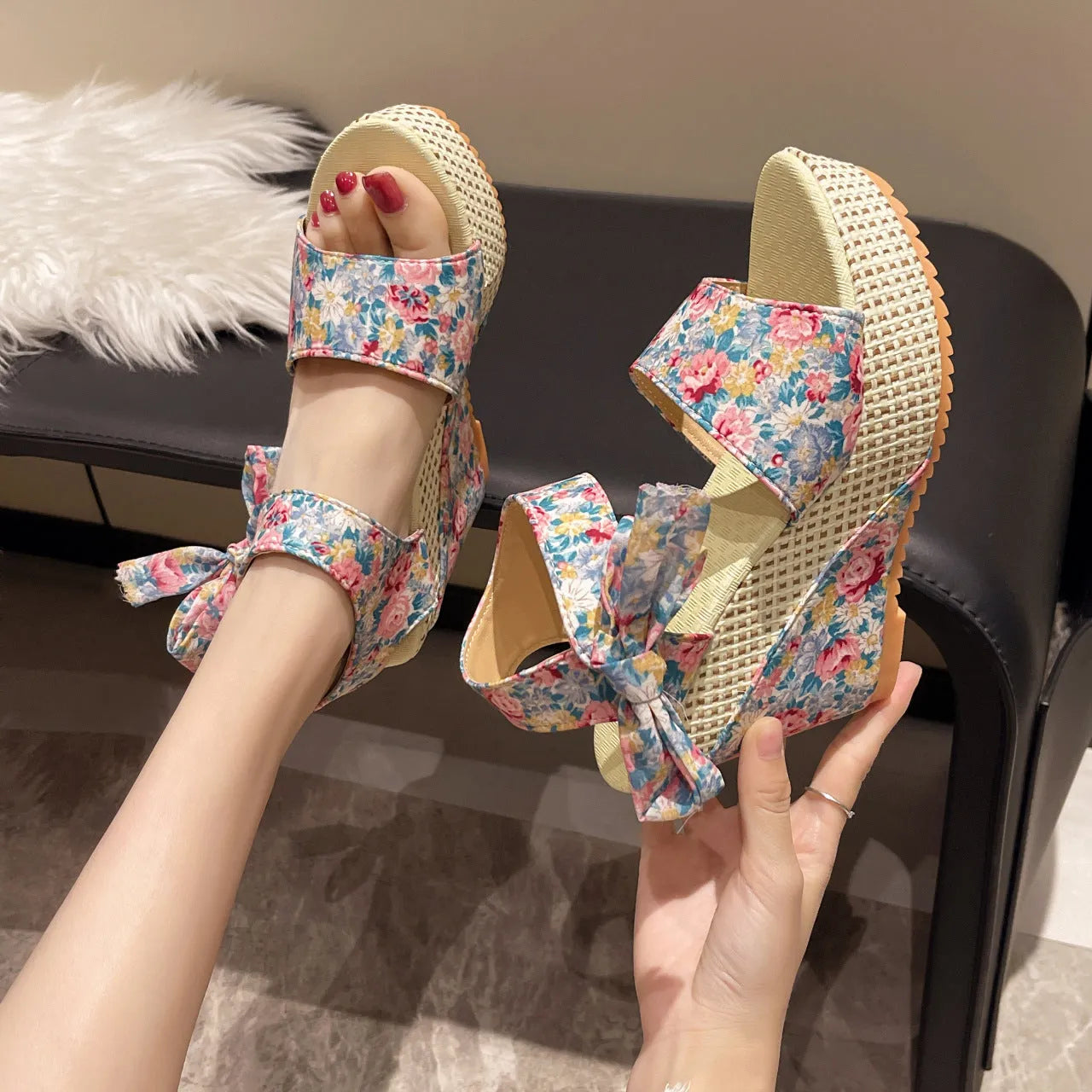 Women's pink floral peep toe wedge sandals with an ankle strap buckle on a rubber sole.