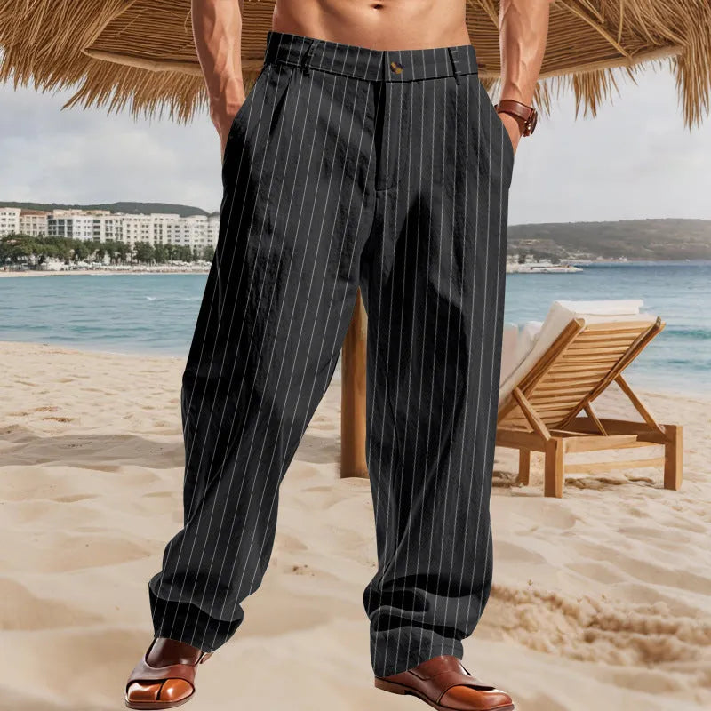 Man wearing loose-fit high-waist striped linen trousers in a light blue colour.
