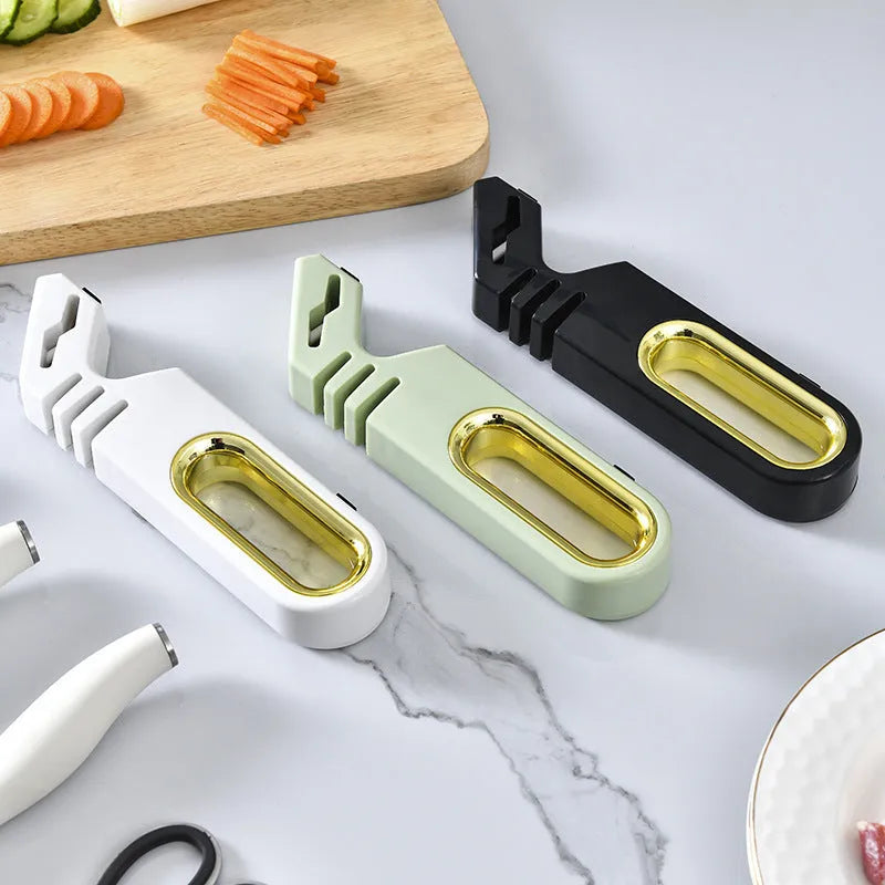 Four-in-one stone manual grinder for sharpening kitchen knives in pearl white colour, with ceramic and diamond stages visible
