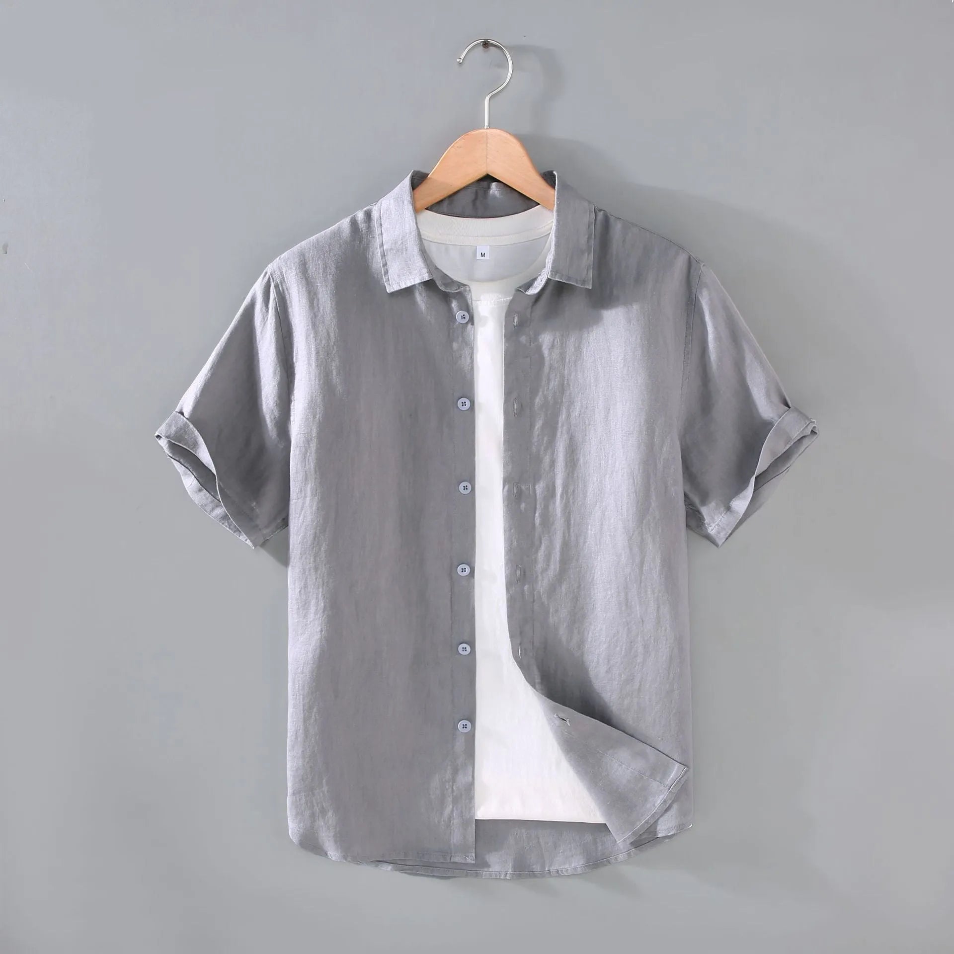 Man wearing a grey short-sleeved linen shirt in a casual cardigan style.
