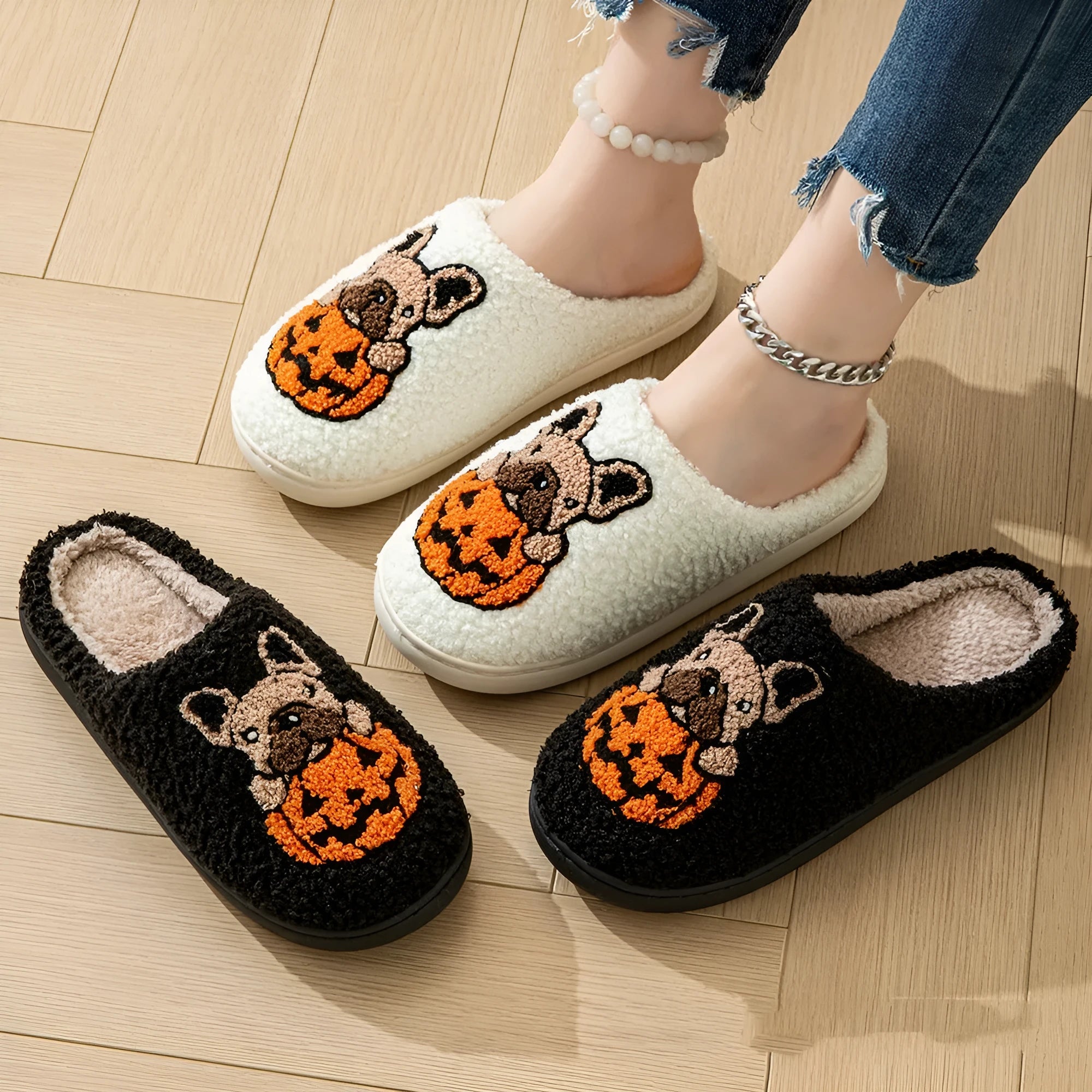 Black and white Halloween plush slippers with pumpkin pattern and non-slip rubber soles.
