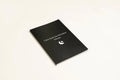 Black hardcover A5 dream journal notebook with lined pages open on a surface.